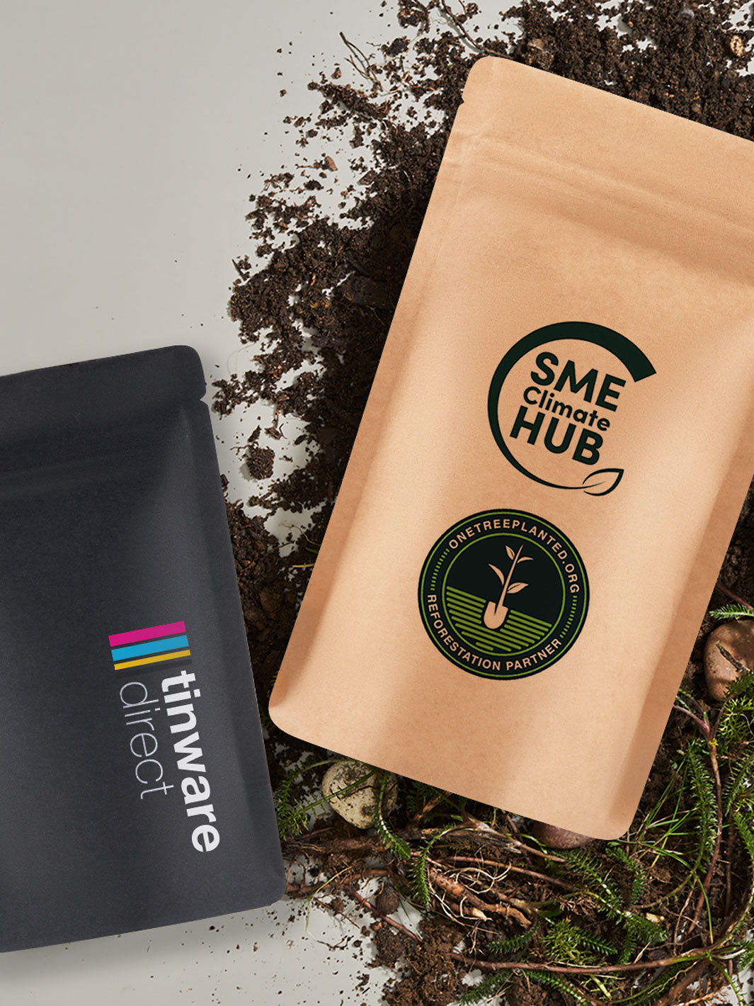 Home compostable stand up pouch packaging with official labeling resting on soil. 