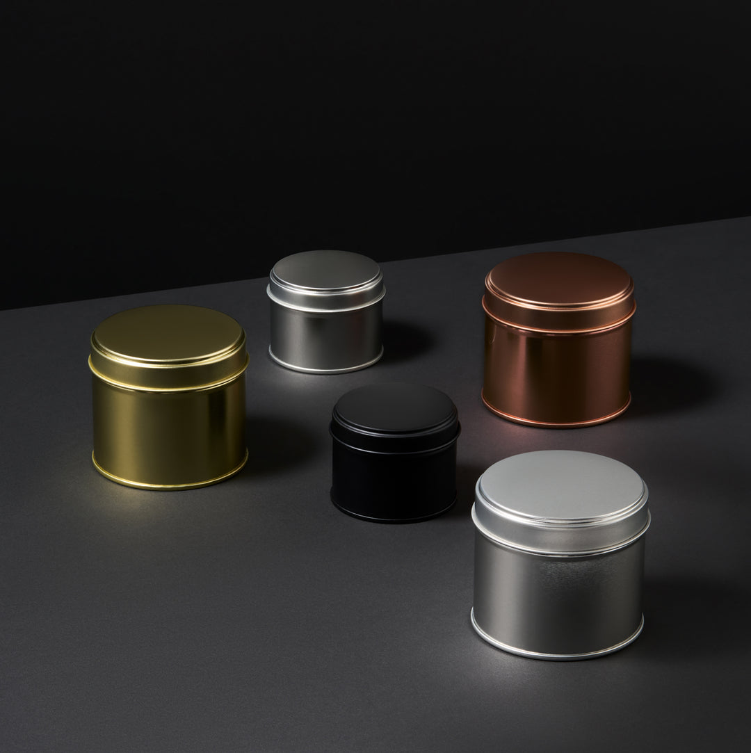 Collection of welded side seam tins in black, rose gold, silver, and gold